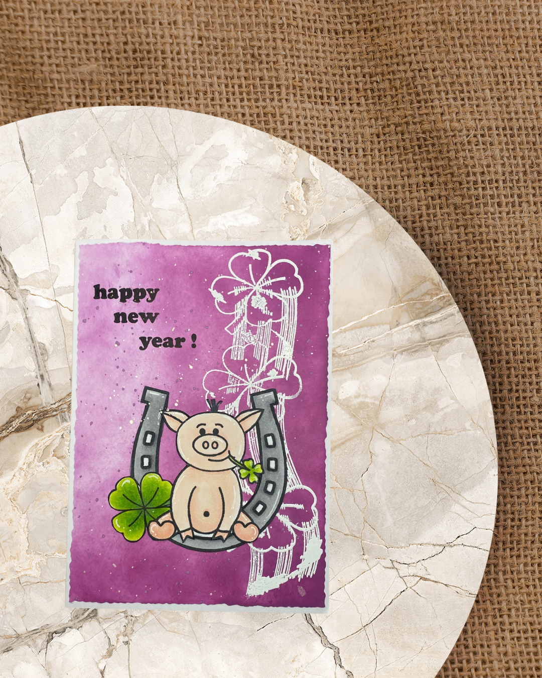 Karte mit Schweinchen sitzend auf einem Hufeisen, Text Happy new Year