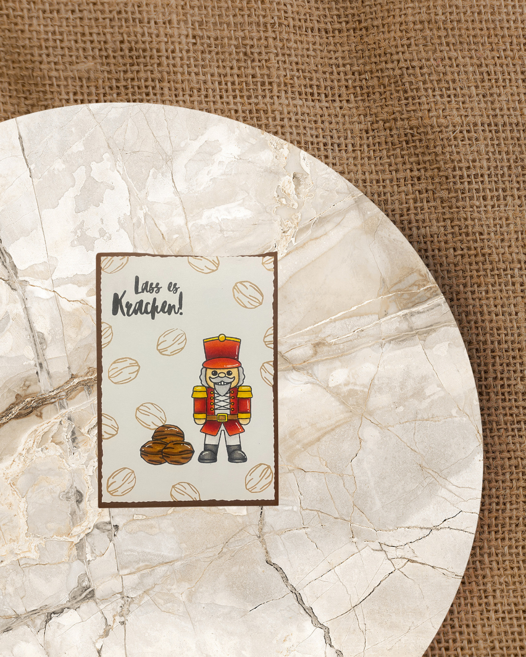 Braune Karte mit rotem Nussknacker und Nüssen