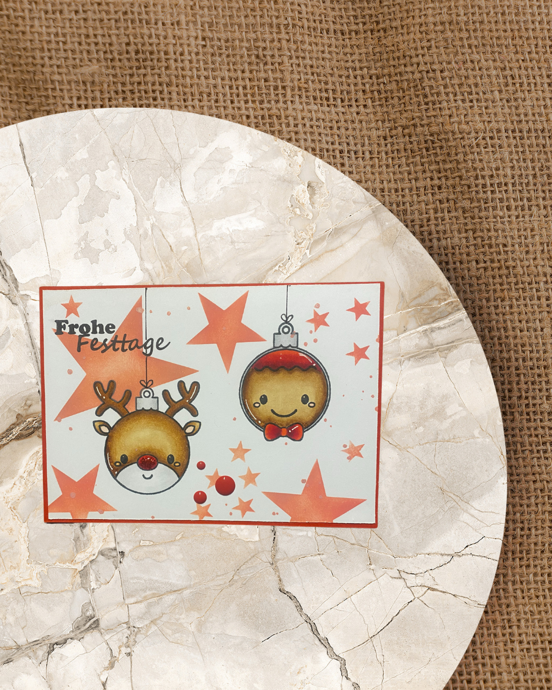 Karte mit roten Sternen und Weihnachtskugeln als Lebkuchenmann und Rentier mit Frohe Festtage