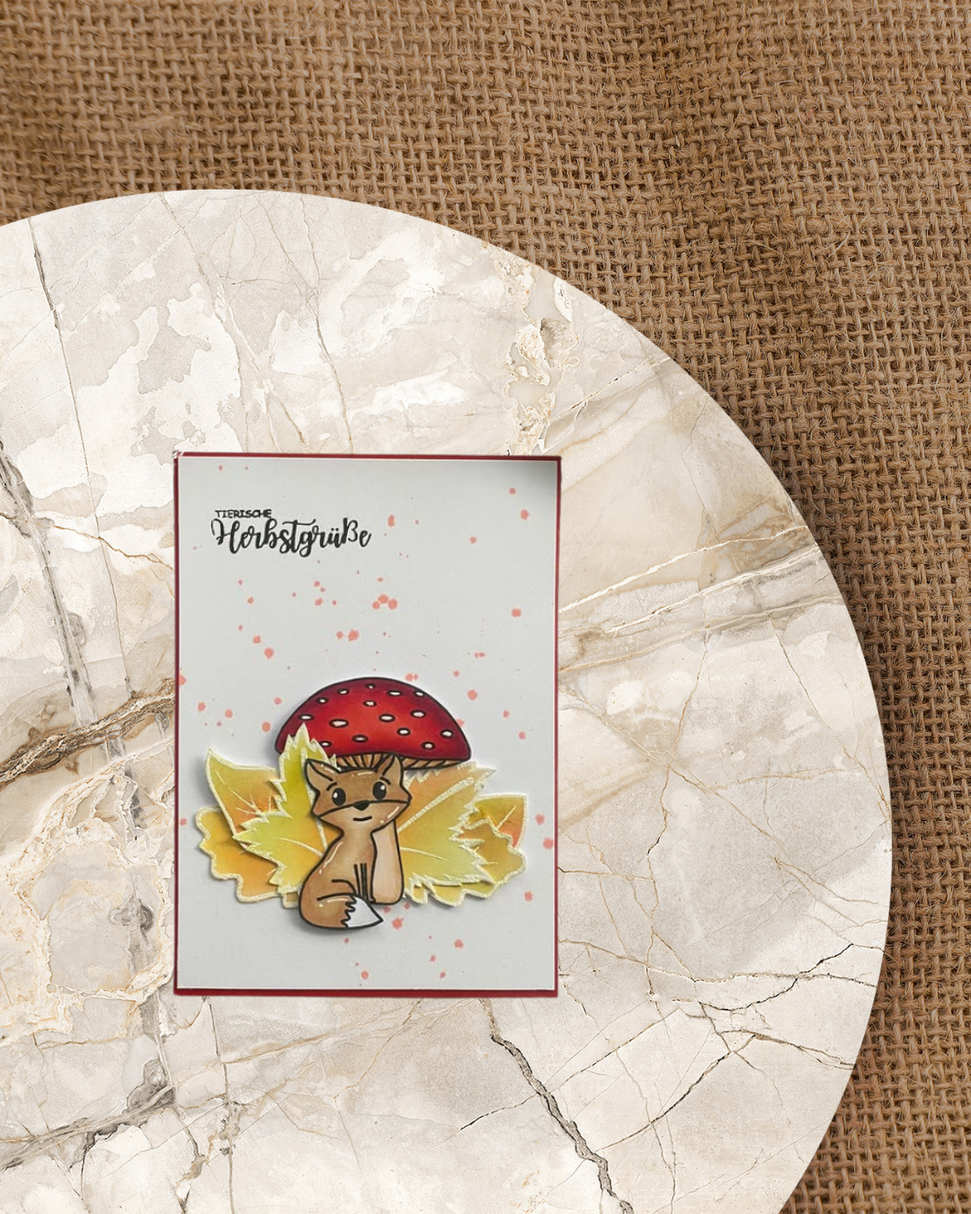Karte mit einem Fuchs der vor einem Pilz und Herbstblättern sitzt. Spruch Tierische Herbstgrüße