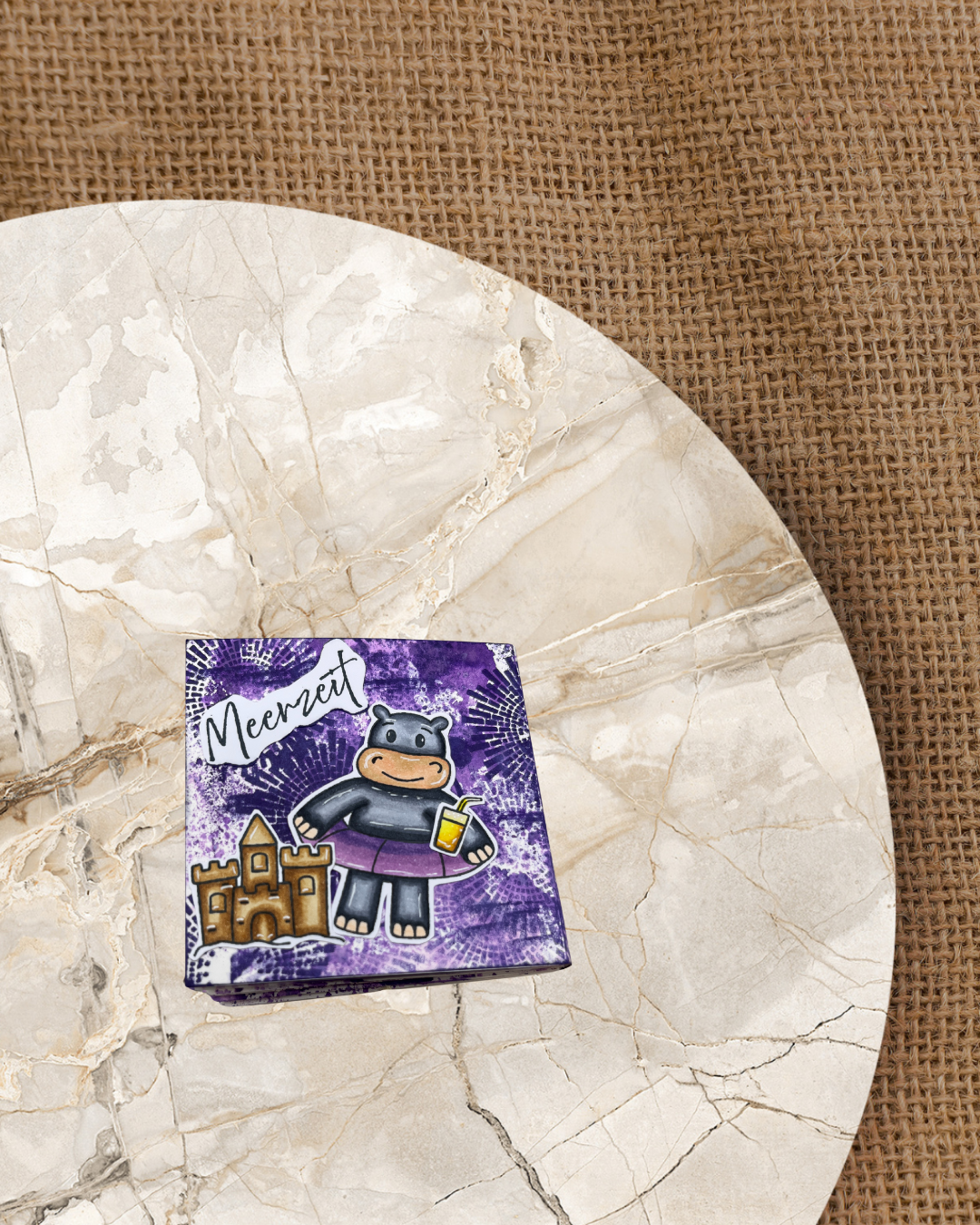 Kleines Album mit Nilpferd und Schwimmring dazu ein Cocktail und Standburg. Hintergrund ist dunkellila. Spruch Meerzeit.