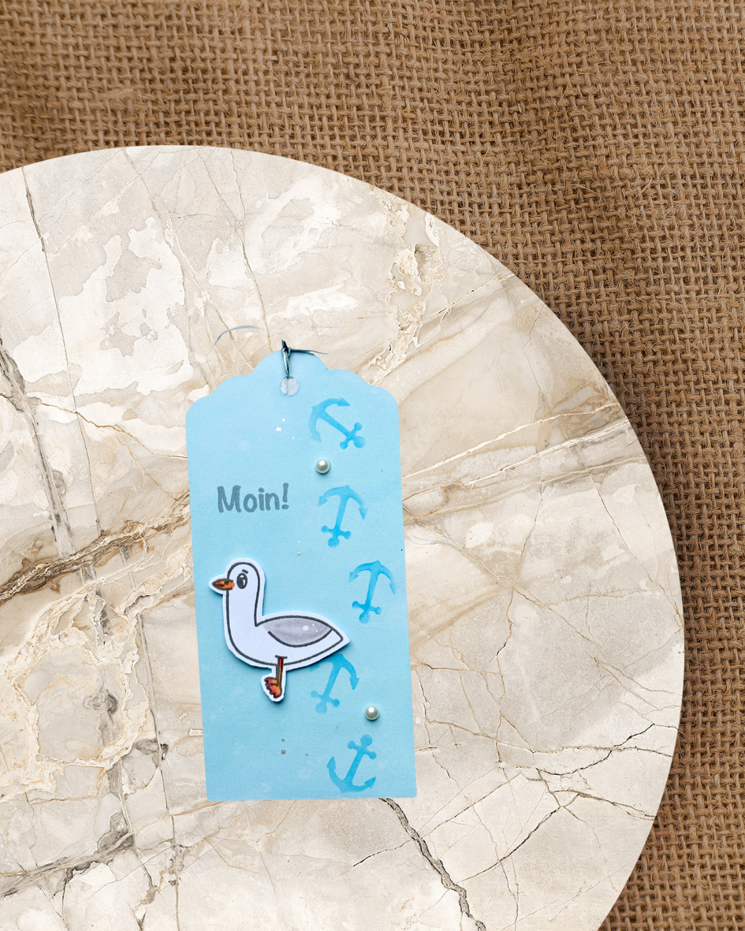 Anhänger mit einer Möwe, Anker und Schrift Moin