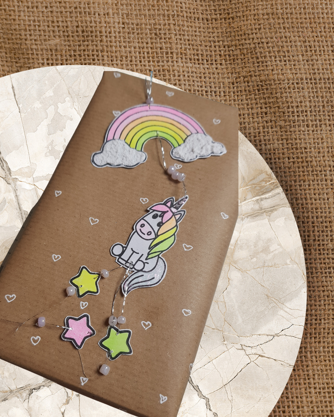 Geschenkpapier verziert mit Sterne Regenbogen und ein Einhorn
