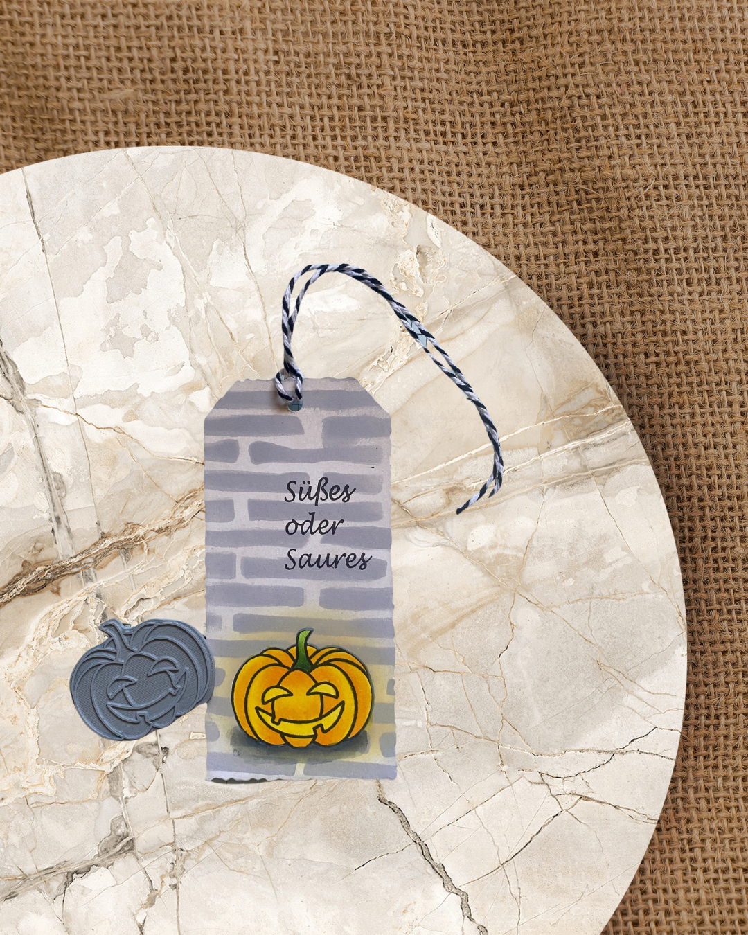 Anhänger mit einem leuchtenten Kürbis vor einer Mauer. Stempel Halloween Kürbisse