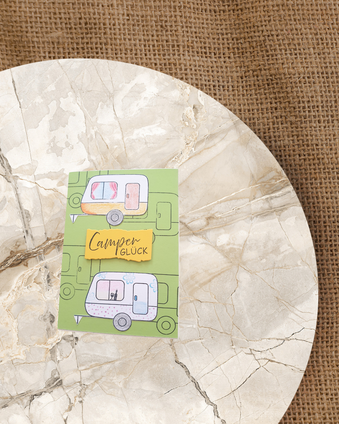2 Wohnwagen auf einer grüner Karte mit einem orangenem Schild Camper Glück