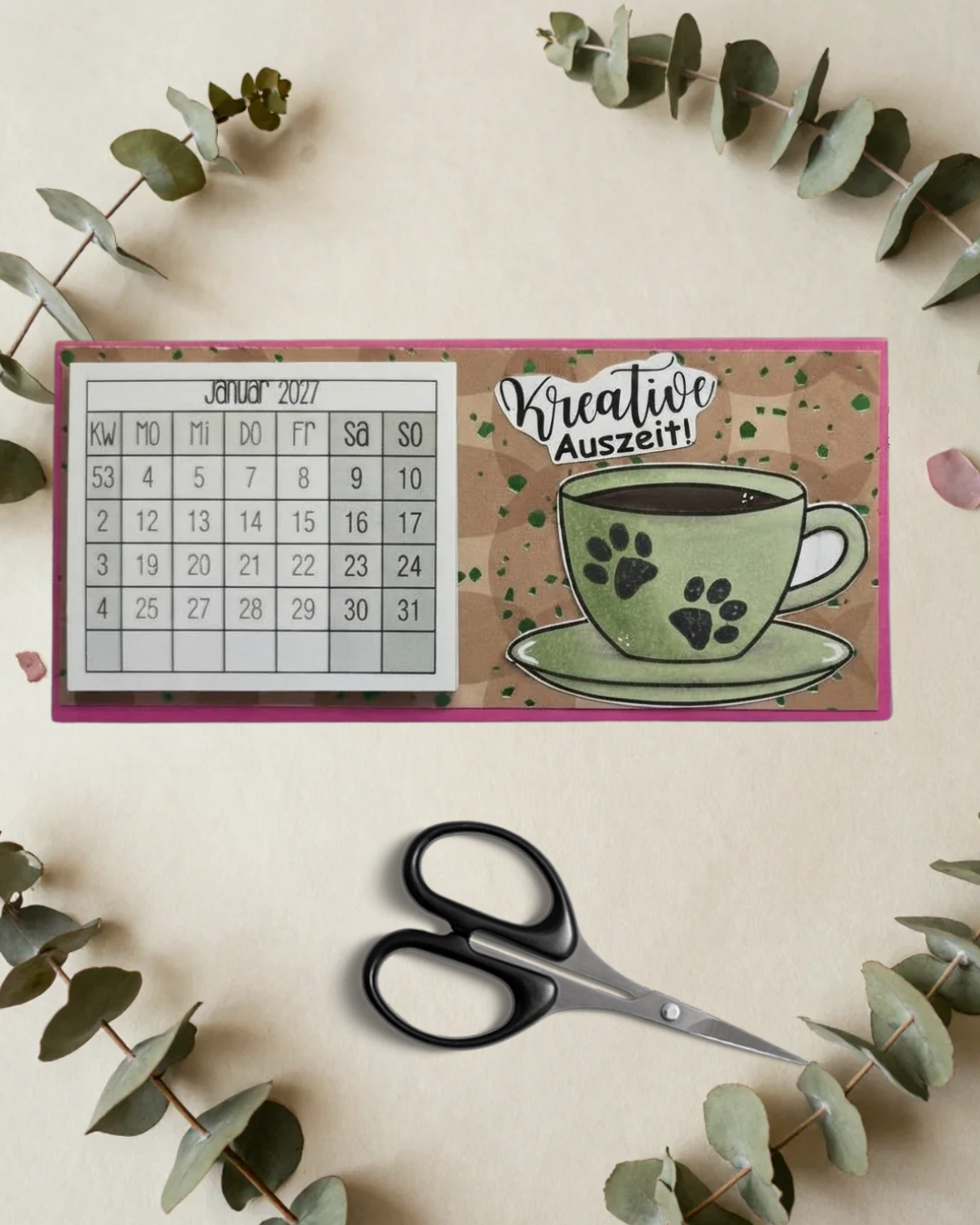 Tischkalender fürs neue Jahr auf der linken Seite Kalender auf der rechten mit einer Tasse. Auf der Tasse 2 Pfoten abdrücke